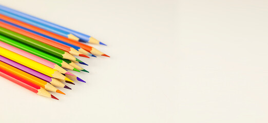 Fototapeta premium Back to school. Multicolored pencils on a light background with copy space. The concept of learning, education. High quality photo