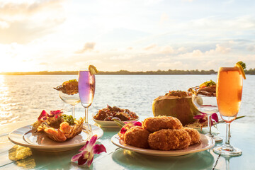 Thai cuisine set with a waterfront restaurant at sunset. - obrazy, fototapety, plakaty