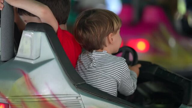 Children having fun at bumper car at the fun fair. little boy driving dodgem cars. Childhood entertainment at amusement park