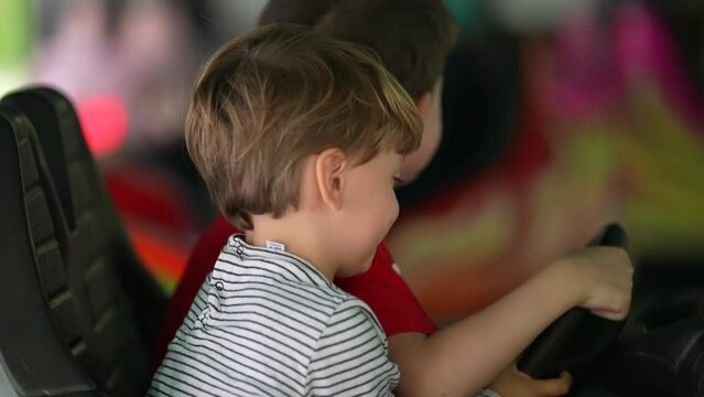 Children having fun at bumper car at the fun fair. little boy driving dodgem cars. Childhood entertainment at amusement park