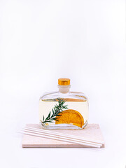 Reed diffuser with cinnamon and orange on white background