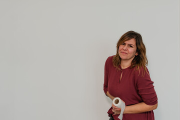 woman with pained face holding toilet paper