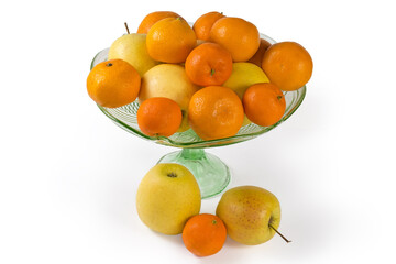 Yellow apples and tangerines in vintage glass vase for fruits