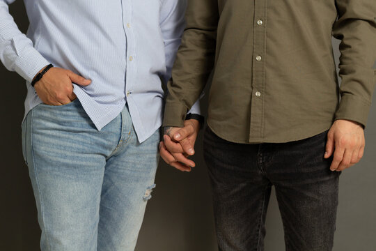 close up photo of gay couple of men holding hands