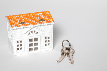 Toys house and keys on isolated white background