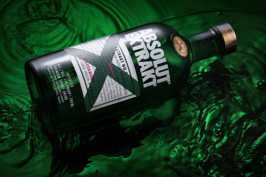 Bottle of Original Absolut Extrakt in water on a green background.