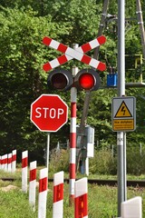 railway crossing on a forest road, the sign says not to touch the electric traction