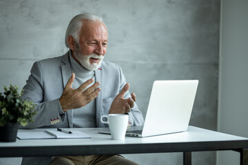 Senior businessman talking on a video call and smiling