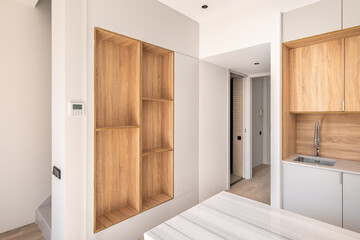 Modern kitchen with wooden furniture, gray countertop and built-in appliance in minimalist interior design