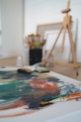 Brushes with canvas on working studio background. Vertical image.