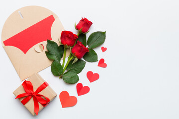 Valentine day composition with envelope, rose flower and red heart on table. Top view, flat lay, copy space Holiday concept