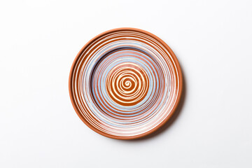 Top view of isolated of colored background empty round brown plate for food. Empty dish with space for your design