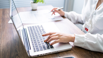 Woman working by using a laptop computer Hands typing on keyboard. writing a blog. Working at home are in hand finger typewriter