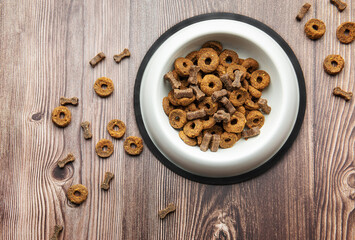 A bowl of dog food on a wooden floor.