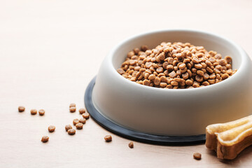 A bowl of dog food on a wooden floor.