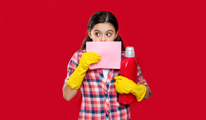 girl with softener detergent hiding behind duster in studio. girl with softener detergent