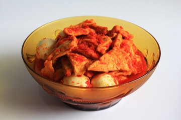Tahu bali or balinese seasoned tofu is Indonesian food made from fried tofu and eggs prepared with spices: shallots, garlic, large red chilies, brown and white sugar, isolated on white background.