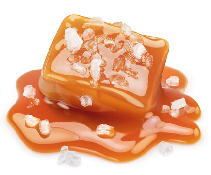 Salty caramel candy in milk caramel sauce with salt crystals isolated on white background.