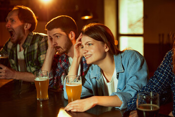 Group of young people, friends meeting at pub to watch sport match translation. Losing game. Stressful emotions.