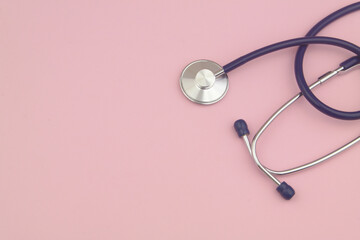 Stethoscope on pink background with copy space for text. Symbol of medicine and health care.