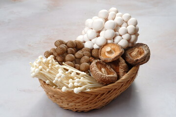 Mushrooms. Fresh Organic, enoki, shiitaki, button mushrooms in wooden woven basket at a restaurant. Variety of Mushrooms in a basket,