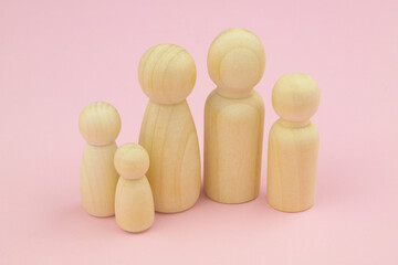 Wooden family people figures on pink background. Family and togetherness concept.