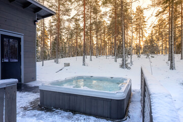 A warm hot tub in crisp winter weather at sunset.