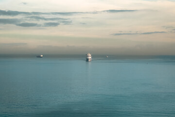 Cruise ship sailing on the Mediterranean Sea with a silhouette sunrise sky