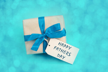 Gift box with ribbon and bow for fathers day, blue bokeh light, surprise for dad, celebrate fatherhood