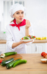Woman chef holding salad and making bellissimo gesture