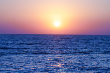 Fototapeta premium Sunset on beach. Sunset with ocean blue water, sky.