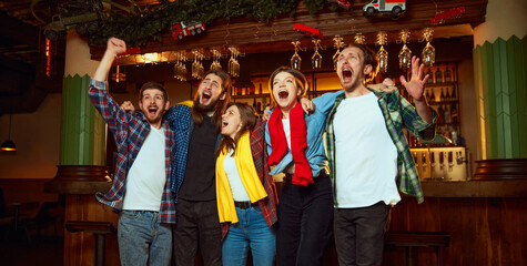 Excited, happy men and women, friends watching match, championship in pub Fans emotional cheering...