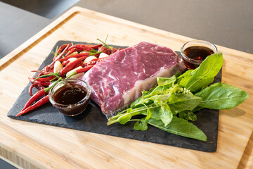 Close up, Raw Beef herb ingredients, basil, garlic, chilli, sauces are prepared on black slate plate for cooking Thai food menu, Stir-fried beef basil.