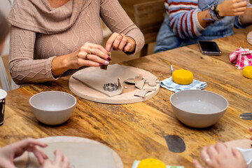 Ceramics workshop. Elderly woman works the clay