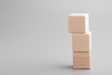 Simple empty wooden dice, one blank cubes made of wood with one central element, gray background. Copy space, logo space in the middle.