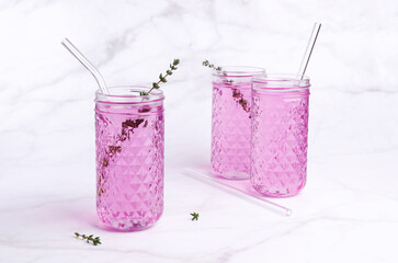Pink drink with thyme in a glass