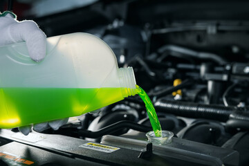 pouring antifreeze coolant liquid into car engine radiator - obrazy, fototapety, plakaty