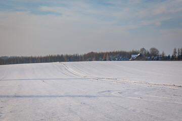 Fototapeta na wymiar Winter fields covered with snow in Lodzkie Voivodeship of Poland