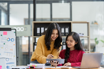 Asian female sales representatives in the section of Real estate talked and discussed tax plans to search for information Ask questions and give advice. All information is recorded and detailed.