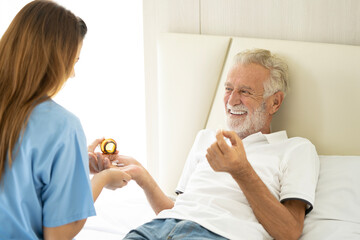 Man being cared for by a private Asian nurse at home suffering from Alzheimer's disease to closely care for elderly patients with copy space on left