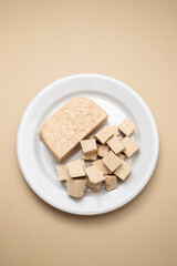 raw tofu block on white small dish on brown