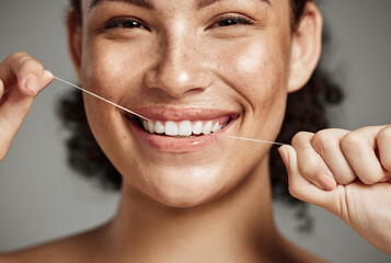 Woman portrait, dental floss and flossing teeth with smile for oral hygiene, health and wellness on studio background. Face of female happy about self care, healthcare and grooming for healthy mouth - obrazy, fototapety, plakaty