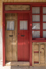 Old wooden front doors - one red and one plain