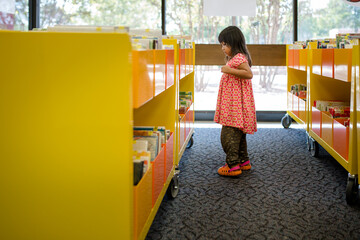 Girl standing up looking at library books