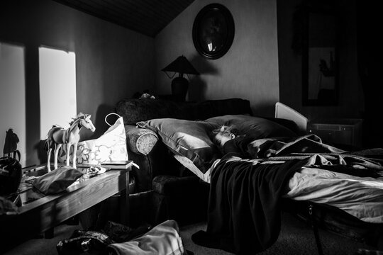 Boy sleeping in dark room with window light