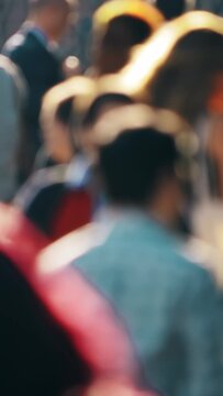 Crowd, unrecognizable people walking, sunny summer day in Manhattan, New York City, defocused, vertical vdeo
