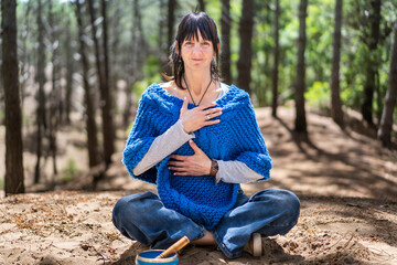 Obraz premium A smiling woman doing breathing exercises while looking at camera.