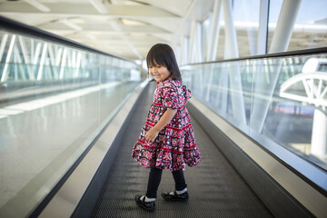 Girl looking back over shoulder on a moving sidewalk
