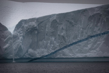 little waterfall over big iceberg wall
