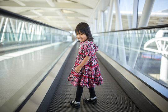 Girl looking back over shoulder on a moving sidewalk